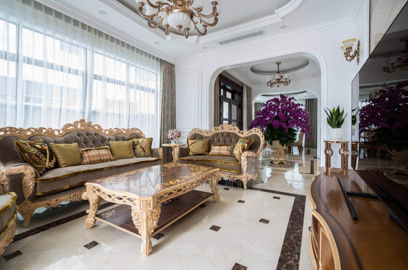 Nội thất tân cổ điển bao gồm bàn, ghế, kệ để tivi được làm từ chất liệu gỗ tự nhiên cao cấp, sofa nỉ, đá hoa cương đèn pha lê Thiết kế nội thất phòng khách biệt thự